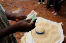 A Malawian trader counts money as he sells maize near the capital Lilongwe, Malawi, February 1, 2016. PHOTO BY REUTERS/Mike Hutchings