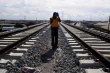 A worker adjusts his hard hat at the National Arts Theatre stop of the light rail system under construction in Lagos, Nigeria, May 30, 2014. Started in 2009 to ease traffic, Lagos state government is building a rail system with the China Civil Engineering Construction Corporation. PHOTO BY REUTERS/Joe Penney
