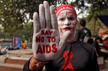 A man poses as he displays his hand and face painted with messages during an HIV/AIDS awareness campaign on the eve of World AIDS Day in Kolkata, India, November 30, 2018. PHOTO BY REUTERS/Rupak De Chowdhuri