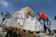 Palestinians check Turkish aid shipments upon arrival in the Gaza Strip at Kerem Shalom crossing between Israel and southern Gaza Strip, July 4, 2016. PHOTO BY REUTERS/Ibraheem Abu Mustafa