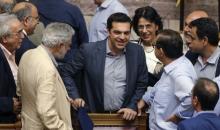 Greek Prime Minister Alexis Tsipras (C) is congratulated by lawmakers after a voting session at the Parliament in Athens, Greece, July 11, 2015. PHOTO BY REUTERS/Christian Hartmann