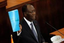 Ivory Coast's President Alassane Ouattara holds the new constitution project document during his speach at the Ivorian parliament in Abidjan, October 5, 2016. PHOTO BY REUTERS/Luc Gnago