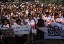 People hold candles as they shout slogans during an anti-violence campaign in central Bangkok