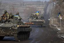 Members of the Ukrainian armed forces ride on armoured personnel carriers (APC) near Debaltseve, eastern Ukraine, February 12, 2015. PHOTO BY REUTERS/Gleb Garanich