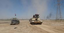 Iraqi security forces ride on a tank during a military operation to fight against Islamic State militants in the town of Hit in Anbar province, April 2, 2016. PHOTO BY REUTERS/Stringer
