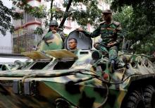 Army soldiers atop an armored military vehicle drive near the Holey Artisan restaurant after Islamist militants attacked the upscale cafe in Dhaka, Bangladesh, July 2, 2016. PHOTO BY REUTERS/Mohammd Ponir Hossain