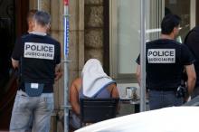 A man covered with a towel is apprehended by French police as the investigation continues two days after an attack by the driver of a heavy truck who ran into a crowd on Bastille Day killing scores and injuring as many on the Promenade des Anglais, in Nice, France, July 16, 2016. PHOTO BY REUTERS/Eric Gaillard