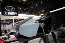 A visitor tries Hyundai's virtual reality driving machine during Auto China 2016 auto show in Beijing, April 25, 2016. PHOTO BY REUTERS/Kim Kyung-Hoon