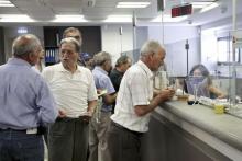 People make transactions at a counter inside a Piraeus Bank branch at the city of Iraklio in the island of Crete, Greece, July 20, 2015. PHOTO BY REUTERS/Stefanos Rapanis