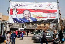 People walk by a poster of Egyptian President Abdel Fattah al-Sisi for the upcoming presidential election, in Cairo, Egypt, March 1, 2018. PHOTO BY REUTERS/Amr Abdallah Dalsh