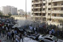 Soldiers, policemen and medical personnel gather at the site of explosions near the Iranian embassy (L) in Beirut