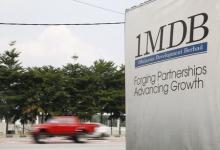 Traffic passes a 1Malaysia Development Berhad (1MDB) billboard at the Tun Razak Exchange development in Kuala Lumpur, Malaysia, July 6, 2015. PHOTO BY REUTERS/Olivia Harris