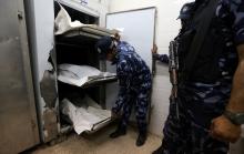 Palestinian Hamas police officers stand next to the bodies of Hamas gunmen, who were killed in an explosion, at a hospital morgue in the central Gaza Strip, May 5, 2018. PHOTO BY REUTERS/Ibraheem Abu Mustafa