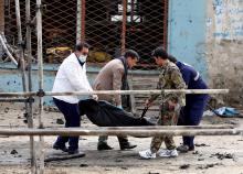 Afghan officials carry the dead body of a victim at the site of a suicide bomb attack near a Shi'ite mosque in Kabul, Afghanistan, March 9, 2018. PHOTO BY REUTERS/Omar Sobhani