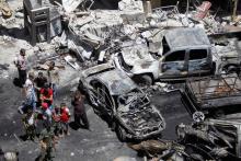People and Syrian Army members inspect a damaged site after a suicide and car bomb attack in south Damascus Shi'ite suburb of Sayeda Zeinab, Syria, June 11, 2016. PHOTO BY REUTERS/Omar Sanadiki