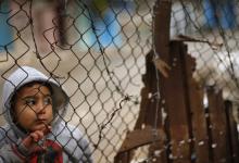 A Palestinian boy looks through a fence near his family's house (not seen), that witnesses said was damaged by Israeli shelling during a 50-day war last summer, in the east of Gaza City, January 7, 2015. PHOTO BY REUTERS/Suhaib Salem