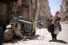 A boy walks along a damaged street at the city of Douma in Damascus, Syria, April 16, 2018. PHOTO BY REUTERS/Omar Sanadiki