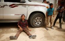The son (L) of one of the Palestinian members of Tayseer Al-Batsh's family, who hospital officials said were killed in an Israeli air strike, mourns during their funeral in Gaza City, July 13, 2014. PHOTO BY REUTERS/Mohammed Salem