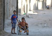 Boys, one of them in a wheelchair, go down a street in the rebel-held al-Sheikh Said neighbourhood of Aleppo, Syria, September 1, 2016. PHOTO BY REUTERS/Abdalrhman Ismail