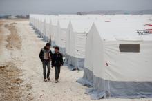 Displaced Syrian boys walk past by tents supplied by Turkish Red Crescent at Kelbit camp, near the Syrian-Turkish border, in Idlib province, Syria, January 17, 2018. PHOTO BY REUTERS/Osman Orsal