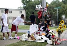 Two boys stand over the makeshift memorial for Michael Brown in Ferguson, Missouri