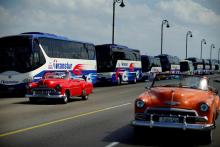 Vintage cars pass by a fleet of Chinese-made Yutong buses parked at the sea front Malecon in Havana, Cuba, February 10, 2017. PHOTO BY REUTERS/Alexandre Meneghini