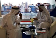 Businessmen speak to each other during the Cityscape real estate exhibition in Dubai, October 2, 2012. PHOTO BY REUTERS/Ahmed Jadallah