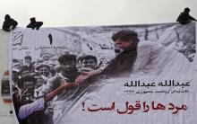 Men install a campaign banner of Afghan presidential candidate Abdullah Abdullah during the first day of the presidential election campaign in Kabul