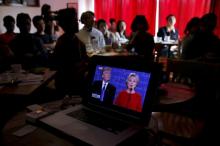People watch live broadcast of the first U.S. presidential debate between Republican U.S. presidential nominee Donald Trump and Democratic U.S. presidential nominee Hillary Clinton at a cafe in Beijing, China, September 27, 2016. PHOTO BY REUTERS/Damir Sagolj