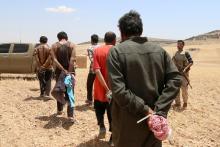 Men, who the Democratic Forces of Syria fighters claimed were Islamic State fighters, walk as they are taken prisoners after SDF advanced in the southern rural area of Manbij, in Aleppo Governorate, Syria, May 31, 2016. PHOTO BY REUTERS/Rodi Said