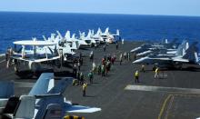 Carrier air crew converge at the flight deck of USS Theodore Roosevelt to guide operating aircraft while transiting the South China Sea, April 10, 2018. PHOTO BY REUTERS/Karen Lema
