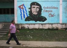 A man walks past near an image of revolutionary hero Ernesto "Che" Guevara in Havana, December 27, 2014. PHOTO BY REUTERS/Stringer