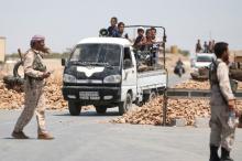 Syria Democratic Forces (SDF) fighters man a checkpoint as civilians on pick-up trucks evacuate from the southern districts of Manbij city after the SDF advanced into it in Aleppo Governorate, Syria, July 1, 2016. PHOTO BY REUTERS/Rodi Said