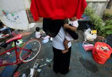 A Rohingya child bride who ran away from her husband carries her sister outside a shack she shares with her mother and siblings, on the outskirts of Kuala Lumpur, Malaysia, February 9, 2017. PHOTO BY REUTERS/Lai Seng Sin