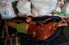 A Rohingya Hindu refugee child lays down next to its mother inside their temporary shelter at the Kutupalong Hindu refugee camp near Cox's Bazar, Bangladesh, December 17, 2017. PHOTO BY REUTERS/Marko Djurica