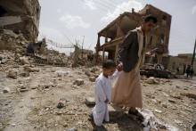 A man and a boy walk at a site hit by a Saudi-led air strike in Yemen's capital Sanaa, July 3, 2015. PHOTO BY REUTERS/Khaled Abdullah
