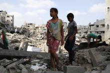 Children stand amid the ruins of their family's apartment that witnesses say was destroyed by Israeli air strikes in the Shejaia neighbourhood in Gaza City