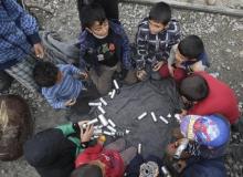 Migrant children play with rubber bullets and empty cases at a makeshift camp for refugees and migrants at the Greek-Macedonian border near the village of Idomeni, Greece, April 11, 2016. PHOTO BY REUTERS/Alexandros Avramidis