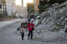 Children walk past the rubble of damaged buildings on the first day of the Muslim holiday of Eid al-Fitr, which marks the end of the holy month of Ramadan, in the rebel held Douma neighbourhood of Damascus, Syria, July 6, 2016. PHOTO BY REUTERS/Bassam Khabieh