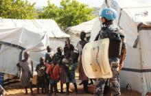 A U.N. peacekeeper stands guard near children displaced in recent fighting, during a visit by the United Nations Security Council, delegation to the UN House in Jebel, near South Sudan's capital Juba, September 3, 2016. PHOTO BY REUTERS/Jok Solomun