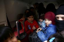 Children hold suitcases during evacuation from the besieged town of Douma, Eastern Ghouta, in Damascus, Syria, March 13. PHOTO BY REUTERS/Bassam Khabieh