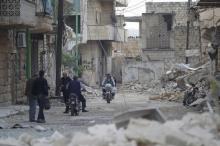 Civilians walk as others ride motorbikes past damaged buildings in the rebel-controlled area of Maaret al-Numan town in Idlib province, Syria, October 29, 2015. PHOTO BY REUTERS/Khalil Ashawi