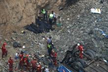 Rescue workers and police work at the scene after a bus crashed with a truck and careened off a cliff along a sharply curving highway north of Lima, Peru, January 2, 2018. PHOTO BY REUTERS/Guadalupe Pardo