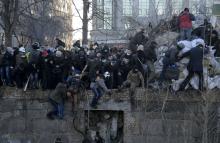 A crowd spreads out as riot police attack anti-government protesters during clashes in Kiev
