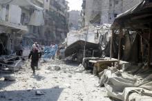 A civil defence member runs at a market hit by air strikes in Aleppo's rebel-held al-Fardous district, Syria, October 12, 2016. PHOTO BY REUTERS/Abdalrhman Ismail