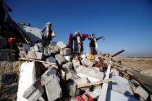 People show clothes of victims at the site of a Saudi-led air strike which struck a house where mourners had gathered for a funeral north of Yemen's capital Sanaa, February 16, 2017. REUTERS/Mohamed al-Sayaghi