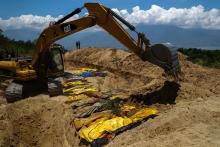 Sand is placed over dead bodies of the victims of the earthquake and tsunami during a mass burial at the Poboya Cemetery in Palu, Central Sulawesi, Indonesia, October 2, 2018. PHOTO BY REUTERS/Athit Perawongmetha