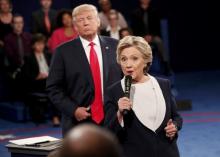 Republican U.S. presidential nominee Donald Trump listens as Democratic nominee Hillary Clinton answers a question from the audience during their presidential town hall debate at Washington University in St. Louis, Missouri, U.S., October 9, 2016. PHOTO BY REUTERS/Rick Wilking