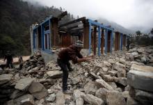 A man clears debris to rebuild a damaged lodge after the earthquake earlier this year in Solukhumbu district, also known as the Everest region, in this picture taken November 28, 2015. PHOTO BY REUTERS/Navesh Chitrakar