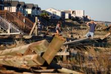 People look through the debris from the pier damaged by Hurricane Matthew in Surfside Beach, South Carolina, U.S., October 9, 2016. PHOTO BY REUTERS/Randall Hill